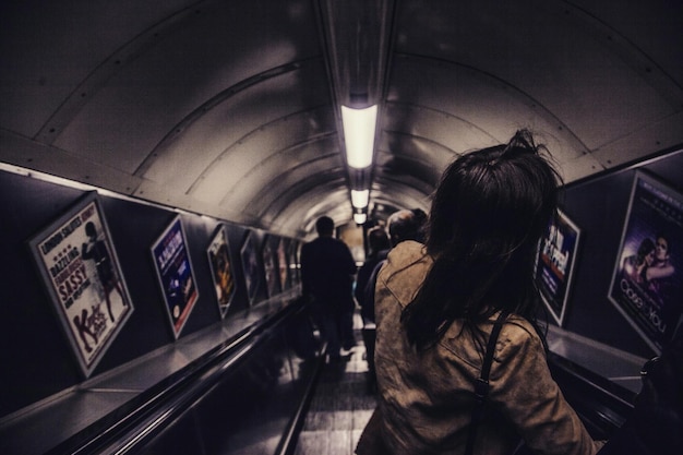 Foto donna sulla scala mobile nel tunnel