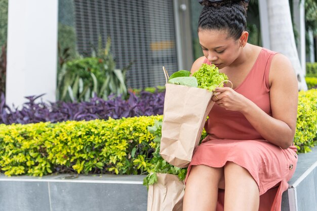 Photo woman examining fresh produce on urban bench