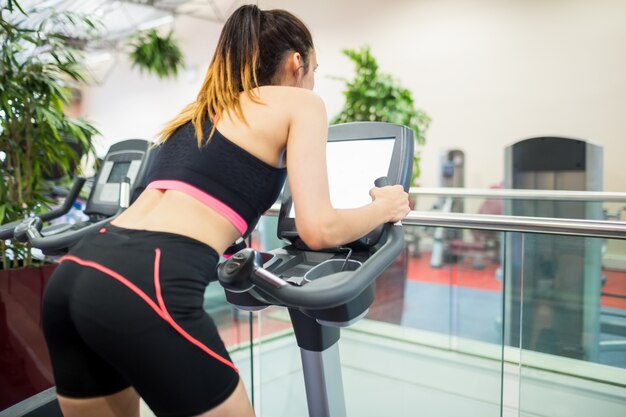 Woman on an exercise bike looking at the tv screen