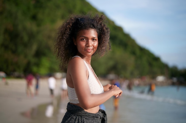 Woman exercises and stretches muscles before outdoor workout Portrait sexy Asian African lady preparing herself for fitness at beach