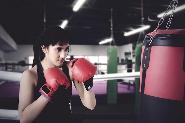 Woman exercises with boxing in the ring