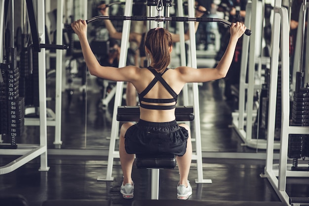 Foto donna che esercita i muscoli della costruzione in palestra