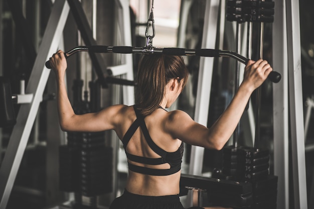 Foto donna che esercita i muscoli della costruzione in palestra