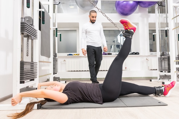 Woman exercising on cable crossover machine at gym