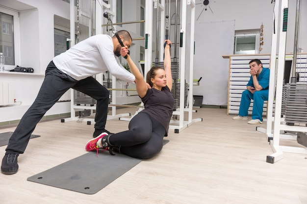 Foto donna che si esercita sulla macchina via cavo con trainer