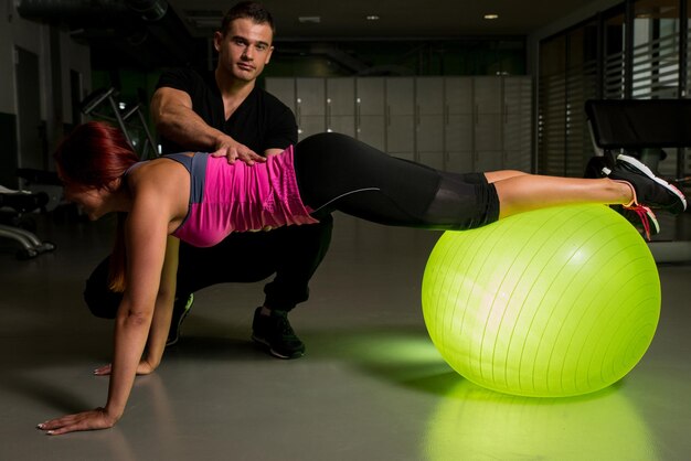 Woman exercising in gym with personal trainer