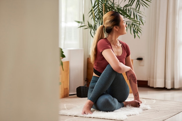 Woman exercising at home. Spine twist