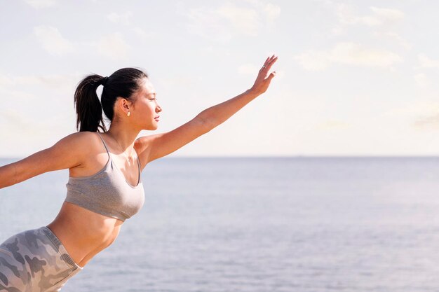 写真 woman exercising on the beach with yoga poses