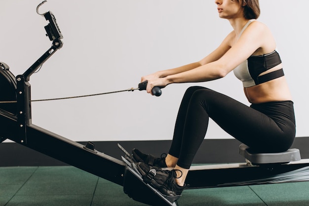 Woman exercising on rowing machine part of circuit training warmup cardio session