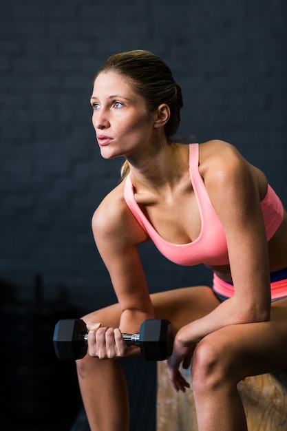 Woman exercising with dumbbell in gym