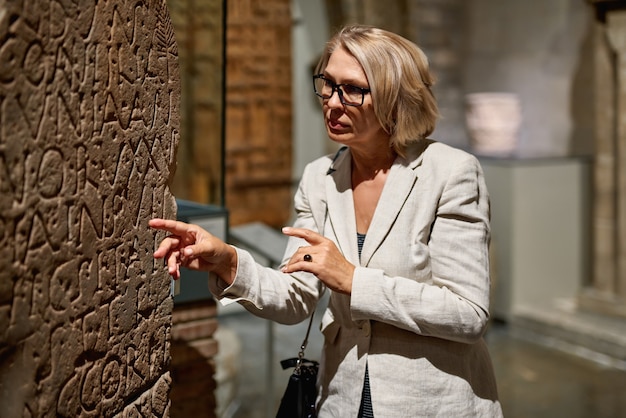 Женщина изучает средневековые экспозиции в музее