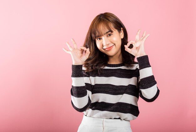 Photo a woman expresses agreement with a smiling face and the ok hand sign in a studio shot on a white                                    person