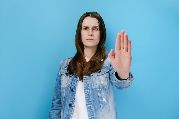 Woman extends palm at camera, prevents you from making mistake