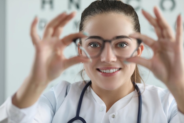 Photo woman eye doctor with eye test chart on background