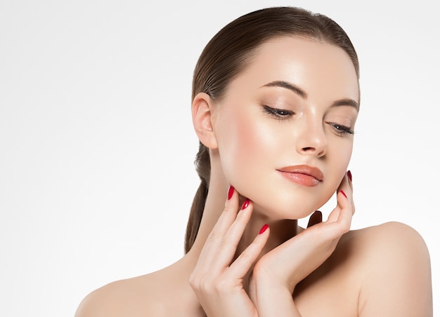 Woman face beauty hand touching face manicure  healthy skin natural makeup beautiful female color background. Studio shot.