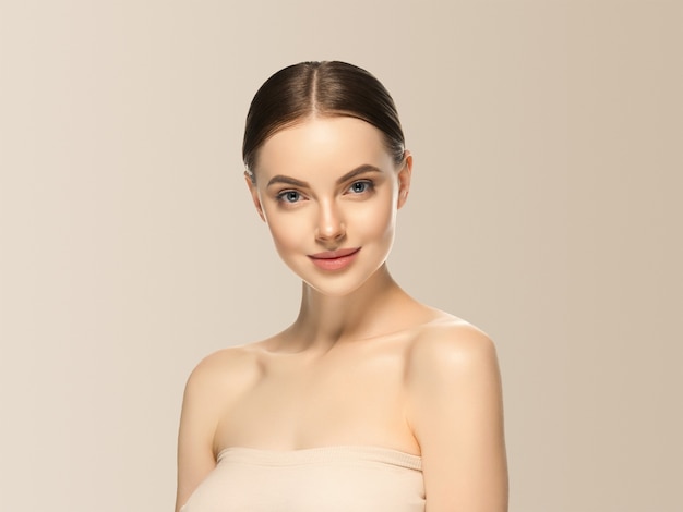 Woman face beauty healthy skin natural makeup beautiful female beige background