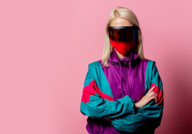 Woman in a face mask and 3D glasses on pink