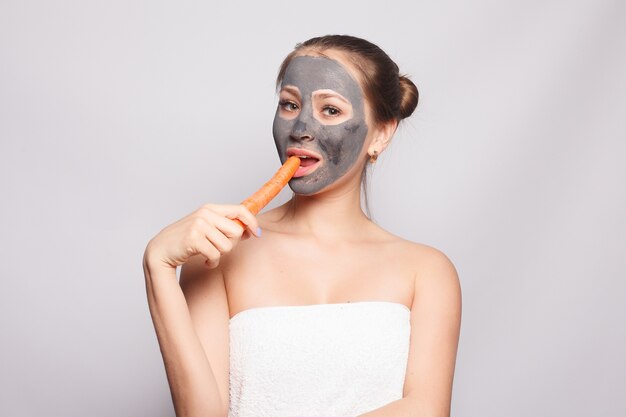 Photo woman face mask. portrait of beautiful girl removing cosmetic black peeling mask from facial skin. closeup of attractive young woman with natural makeup and cosmetic peel mask on face. high resolution