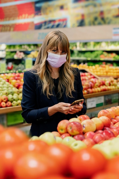 Donna con una maschera facciale mentre fa la spesa in un supermercato durante la quarantena del coronavirus