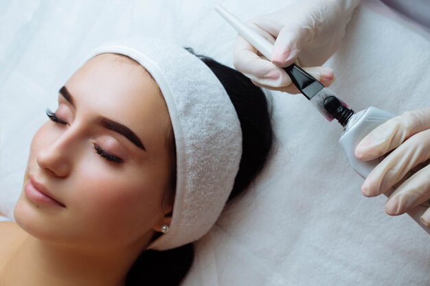 woman face wearing black gloves gorgeous woman in spa having facial procedures