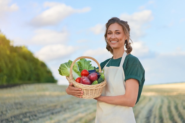 Foto donna agricoltore grembiule permanente di terreni agricoli sorridente agronomo femmina specialista agricoltura agroalimentare felice positivo lavoratore caucasico campo agricolo