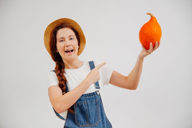 Woman farmer calls for buying fresh organic vegetables pumpkin on a white background