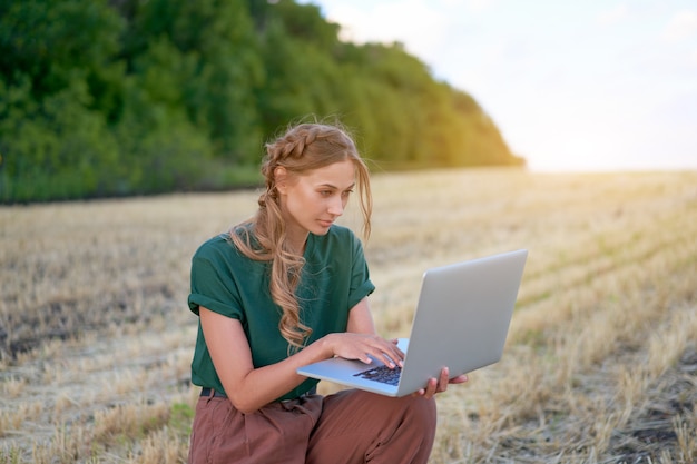 Woman farmer smart farming standing farmland smiling using laptop Female agronomist specialist research monitoring analysis data agribusiness