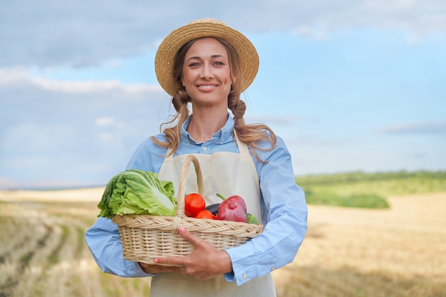 Woman farmer straw hat apron standing farmland smiling