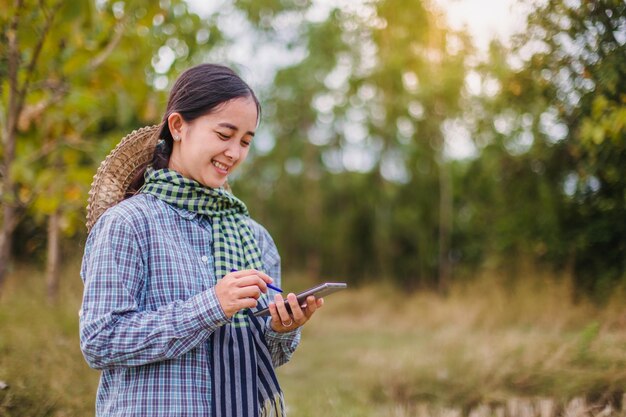 woman farmer using technology mobile in rice field