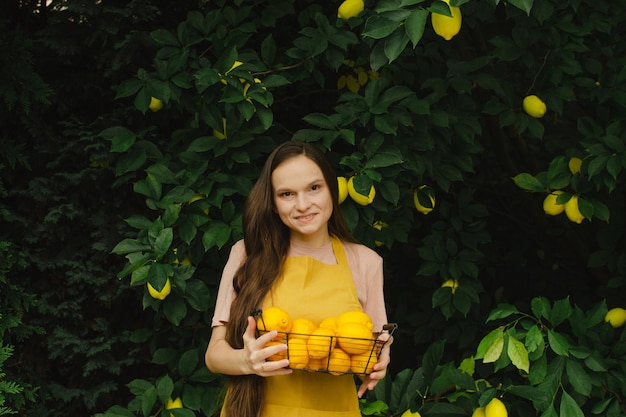 Woman farmer with a basket of lemons in her hands