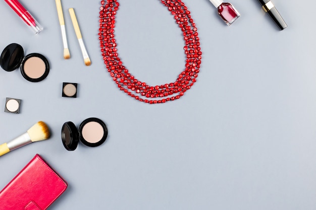 Woman fashion accessories, jewelry and cosmetics on stylish graytable. Flat lay