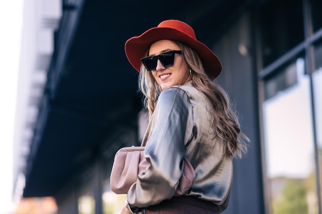 Woman fashion closeup portrait young girl in orange hat and black sunglasses looking at camera