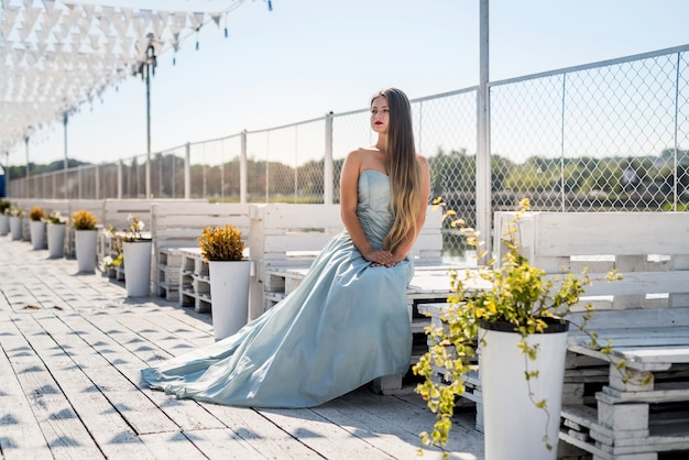 Woman in fashion dress posing on the ocean coast