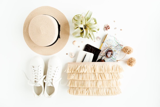 Woman fashion travel straw hat bag with accessories sneakers succulent sunglasses flat lay top view