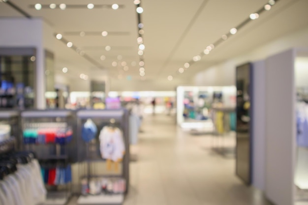 Woman fashionable boutique clothing store window display in shopping mall blur defocused background