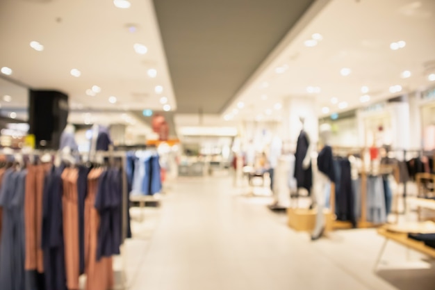 Woman fashionable boutique clothing store window display in shopping mall blur defocused background