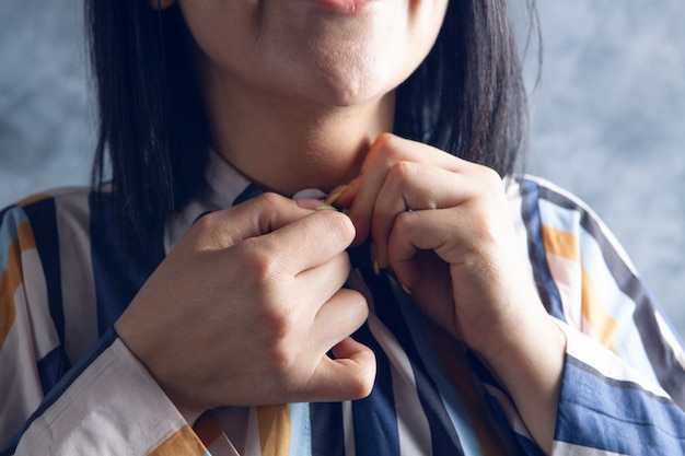 The woman fastens the button of the shirt