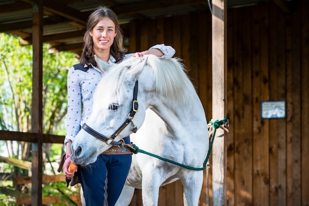 Woman feeding carrot to horse