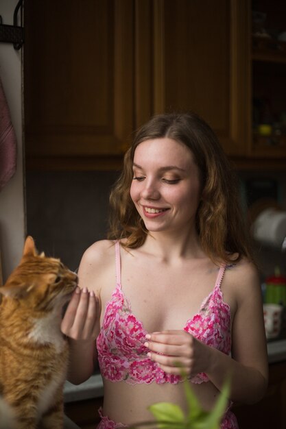 Woman feeding the cat at home happy leisure time