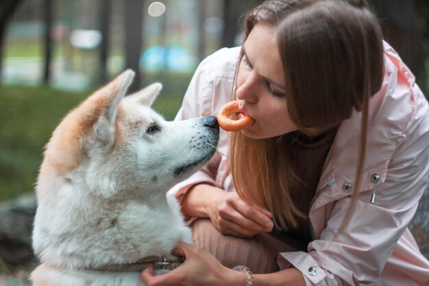 Foto donna che dà da mangiare al cane all'aperto