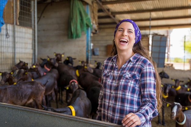 Photo woman feeding the goats on an old farm