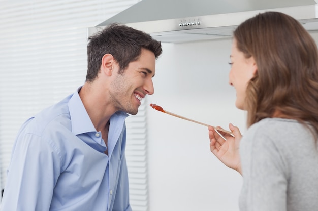 Donna che alimenta il marito mentre cucina