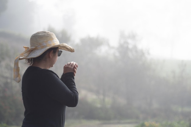 写真 曇りの日に寒さを感じる女性