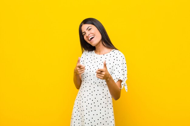 woman feeling happy, cool, satisfied, relaxed and successful, pointing at camera, choosing you