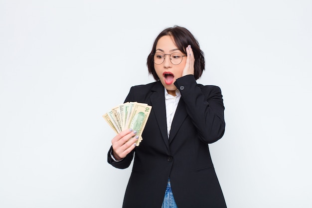 woman feeling happy, excited and surprised, looking to the side with both hands on face