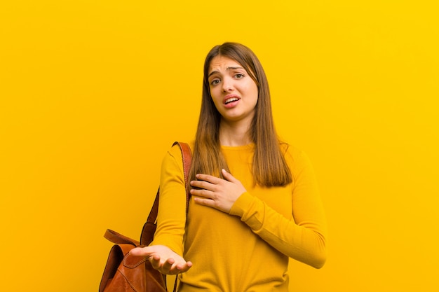 Donna sentirsi felice e innamorata, sorridendo con una mano vicino al cuore e l'altra allungata in avanti