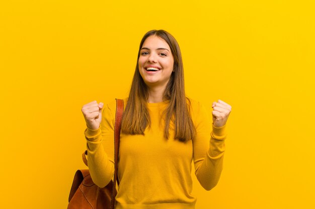 幸せで驚き、誇りに思っている女性、大きな笑顔で叫び、成功を祝っている女性