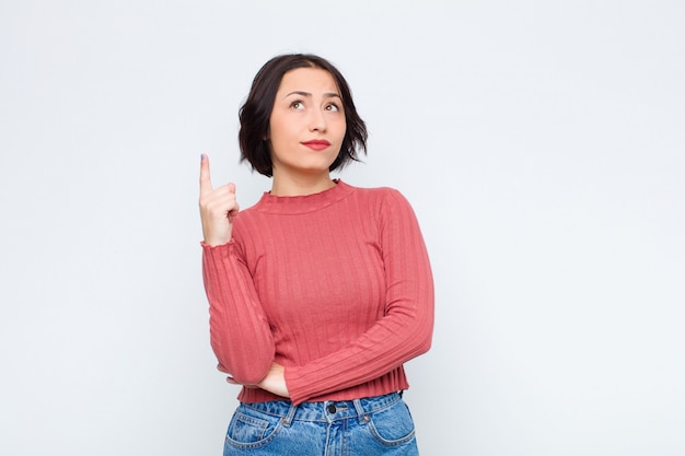 Woman feeling like a genius holding finger proudly up in the air after realizing a great idea, saying eureka