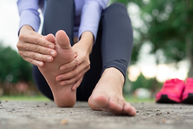 woman feeling pain in her foot during sport outdoor