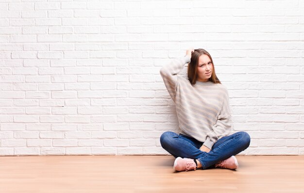 Foto donna sentirsi perplessa e confusa, grattandosi la testa e guardando di lato